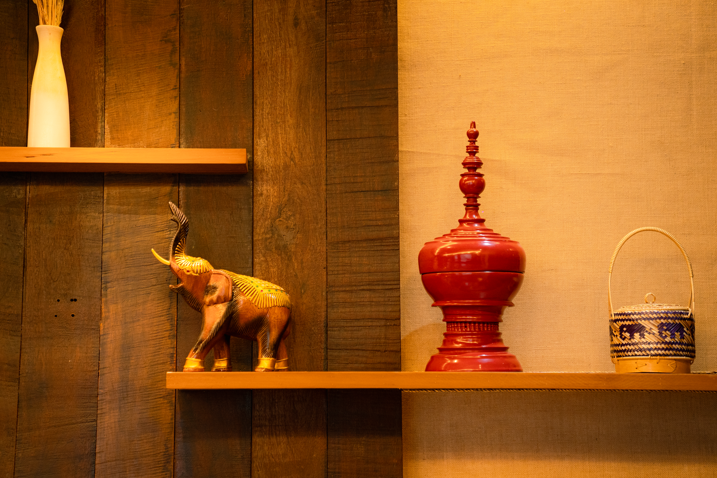 Brass elephant and red lacquerware on the dining room shelves