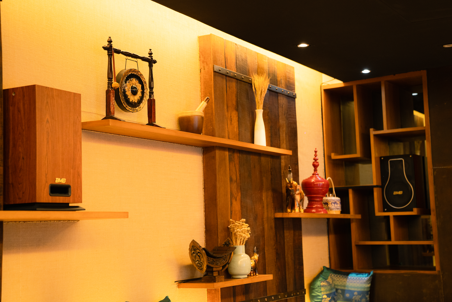 Brass gong and ceramic objects on wooden shelving in the dining room